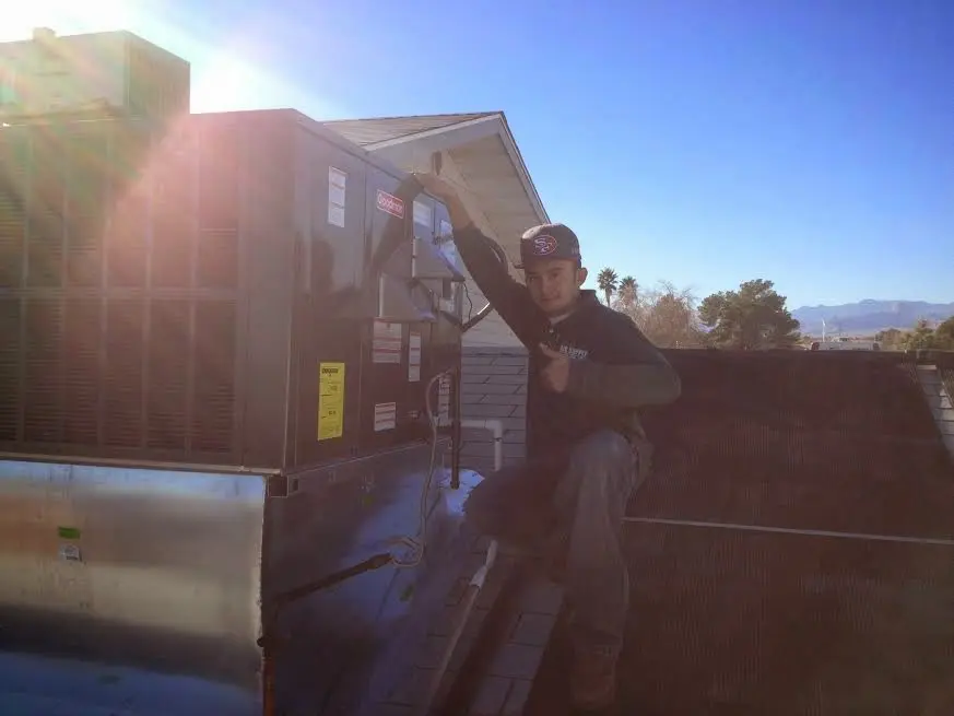 HVAC technician performing Air Duct Cleaning on a rooftop unit in Hollywood